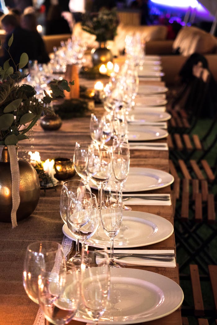 Beautifully arranged candlelit table with wine glasses and decor for an intimate event.